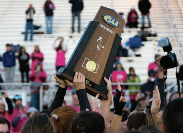 Toast to teamwork: The field hockey team raises its first PIAA 3A State Championship trophy in the air. Following the win, a fire truck from the Berwyn Fire Company temporarily escorted the players to a crowd of supporters waiting at Conestoga.